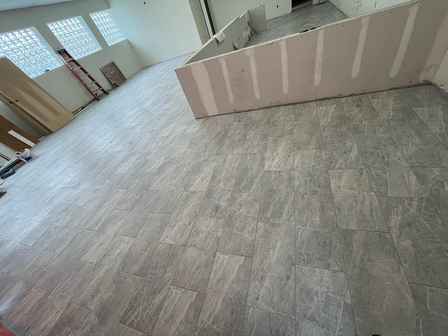 Commercial space mid-buildout with new flooring and drywall partition